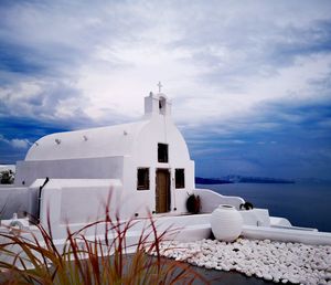 White building by sea against sky