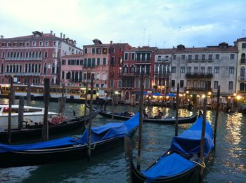 Boats moored in canal against buildings in city