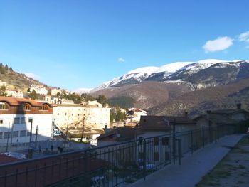 Town by mountain against sky in winter