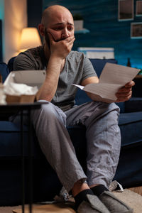 Worried man reading letter at home