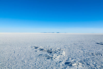 Scenic view of snow covered landscape against blue sky