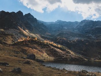 Scenic view of lake by mountains against sky