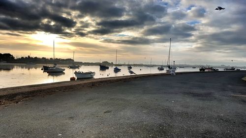 Scenic view of beach against dramatic sky during sunset