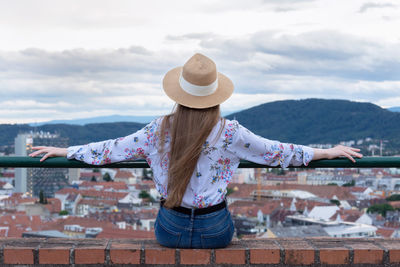 Rear view of woman standing against cityscape