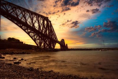 Bridge over river against sky during sunset