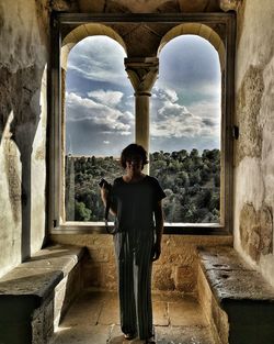 Man standing by historic building against sky