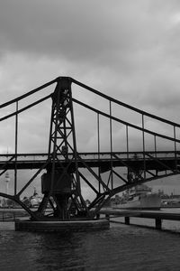 Bridge over river against sky in city