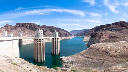 Scenic view of dam and mountains against sky