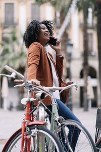 Woman looking at bicycle in city