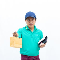 Portrait of young man using smart phone against white background