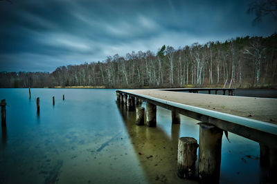 Scenic view of lake by trees against sky