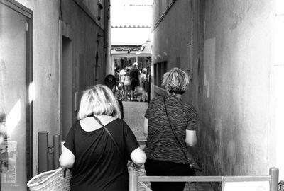 Rear view of people standing on footbridge