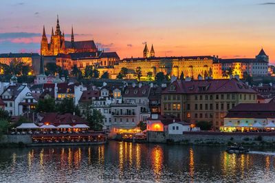 Illuminated buildings against sky at sunset