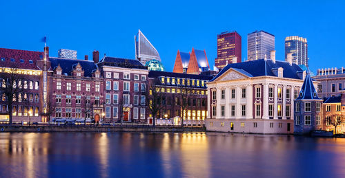 Reflection of buildings on river in city at night