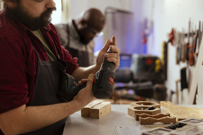 Midsection of man working in workshop