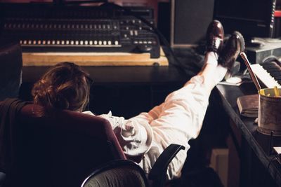 Rear view of musician relaxing on chair at studio