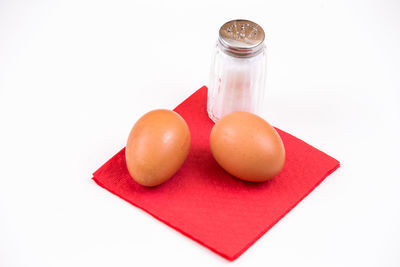 Close-up of eggs in glass jar on white background