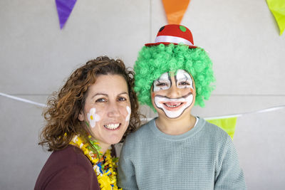 Mother painting her son's face like a clown