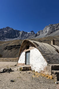 Built structure on landscape against clear blue sky