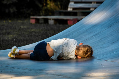 Rear view of boy lying on ramp