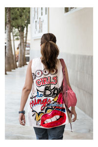 Rear view of woman standing against wall
