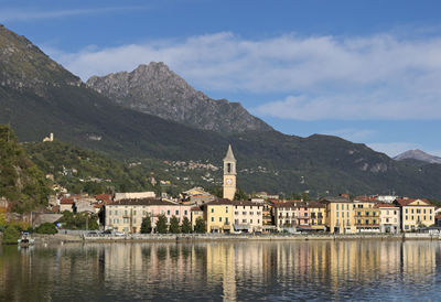 Scenic view of buildings by mountains against sky