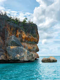 Rock formation in sea against sky