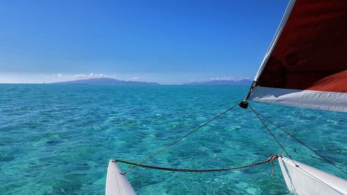 Sailboat sailing on sea against blue sky