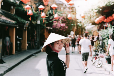 Girl wearing vietnam hat or non la and sightseeing at heritage village in hoi an city in vietnam