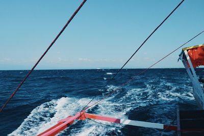 Sailboat sailing on sea against clear sky