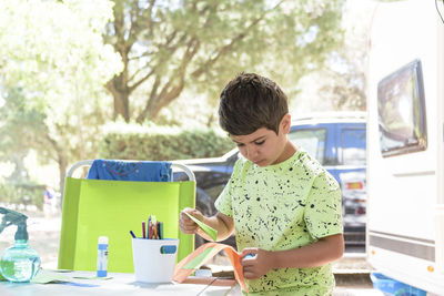 Primary school boy doing manual work while on vacation and preparing to go back to school.