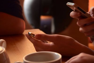 Close-up of woman using mobile phones at table