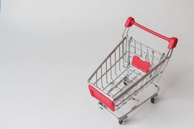 Close-up of miniature shopping cart against white background