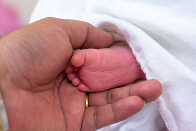 Close-up of hand holding baby foot