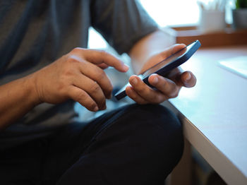 Midsection of man using mobile phone