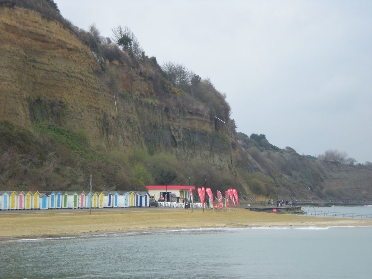 PEOPLE ON BEACH AGAINST MOUNTAINS