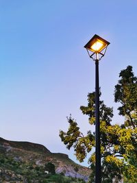 Low angle view of illuminated street light against sky