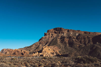 Scenic view of mountains against clear blue sky