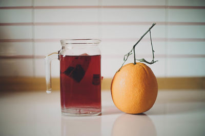 Close-up of orange juice in glass jar on table