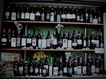 Row of bottles on shelf at market stall