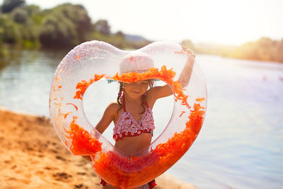 Portrait of young woman with hat in water