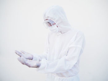 Man wearing hat standing against white background