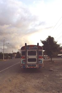 Bus on car against sky during sunset