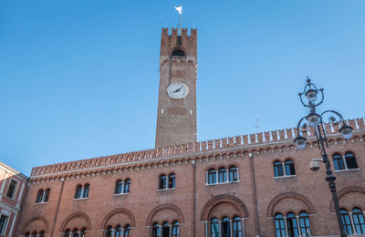 Low angle view of clock tower against blue sky