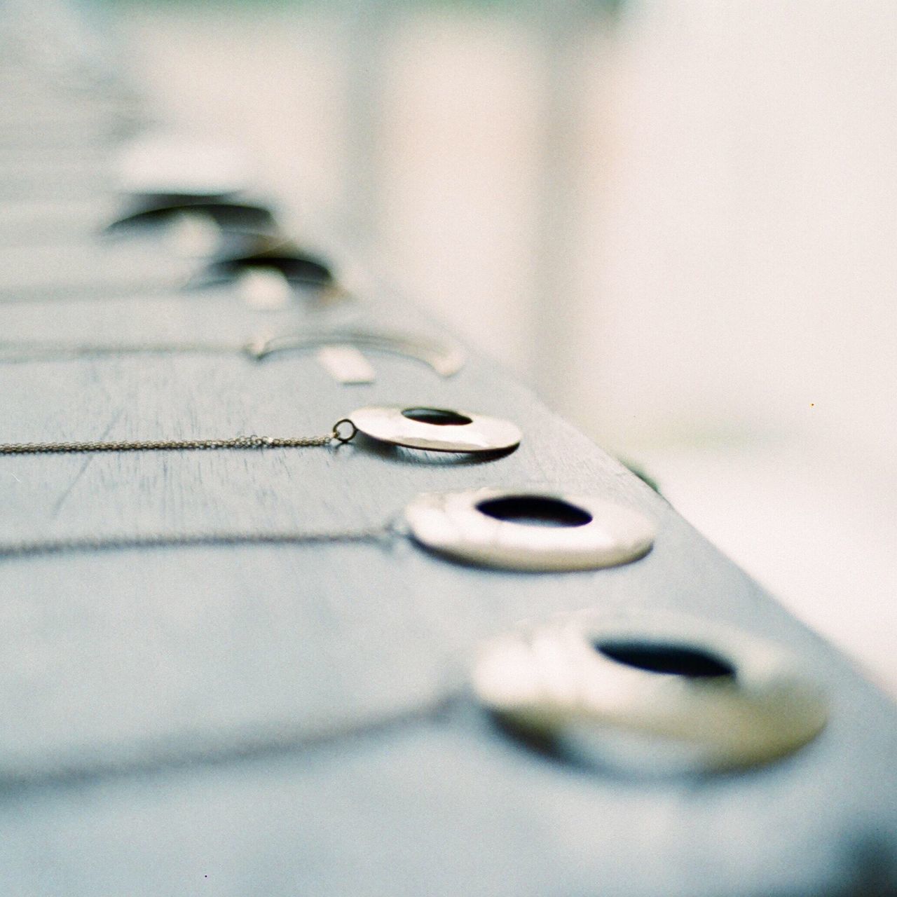 selective focus, indoors, close-up, metal, no people, music, musical instrument string, day