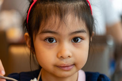 Close-up portrait of cute girl sitting at restaurant
