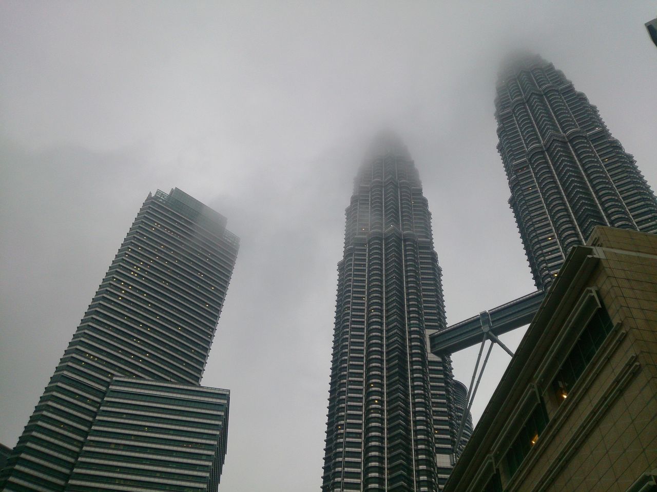 LOW ANGLE VIEW OF SKYSCRAPERS AGAINST CLOUDY SKY