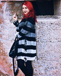 Portrait of woman standing against wall