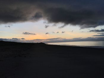 Scenic view of beach against dramatic sky