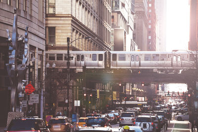 Traffic on road by buildings in city